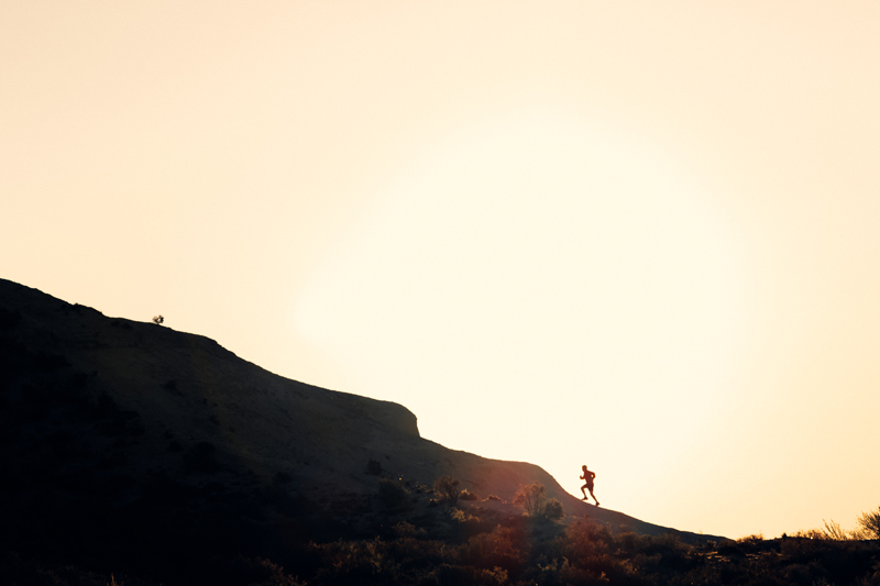 Guy hiking up a mountain during sunset